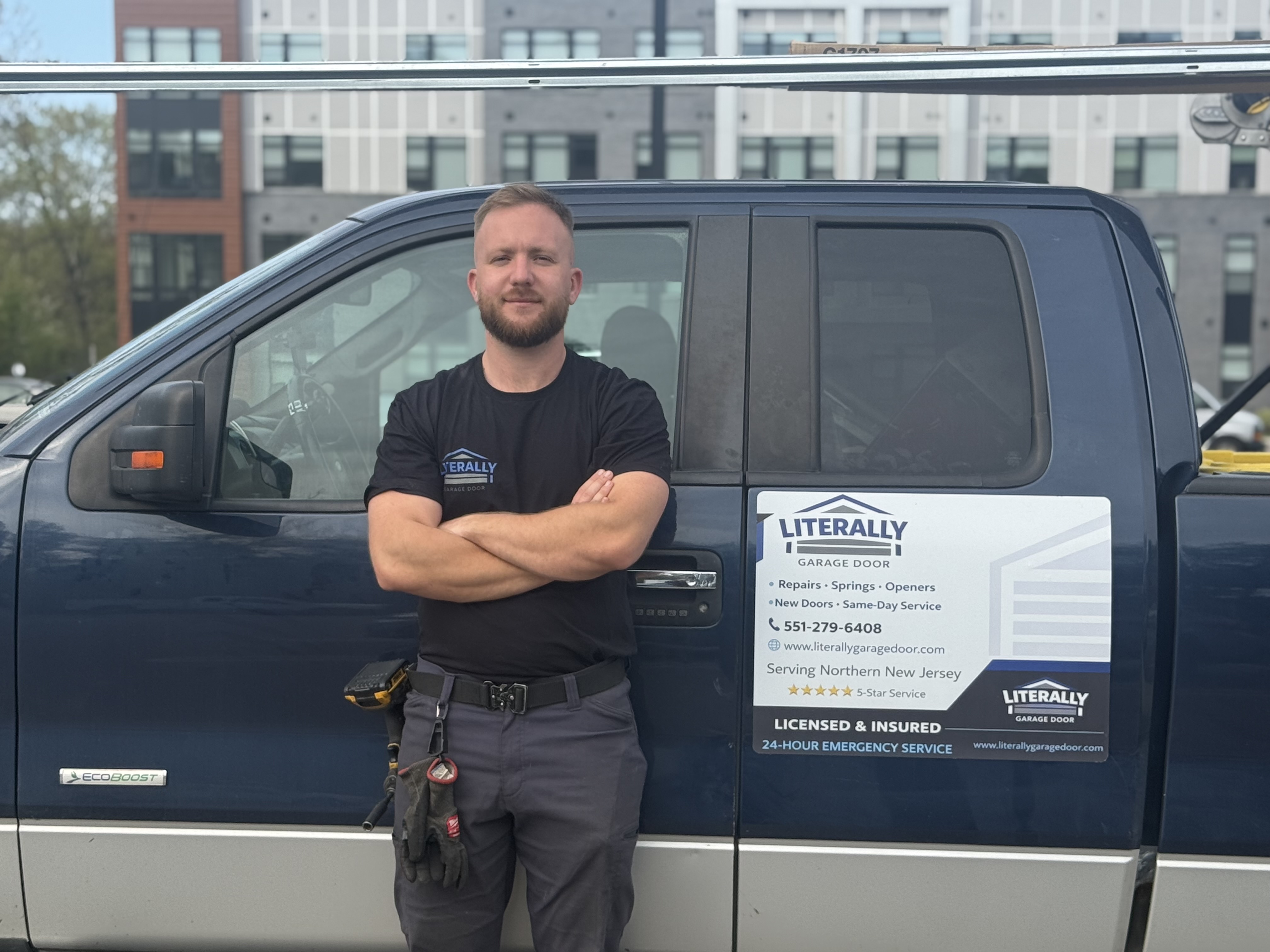 Roni, owner and technician at Literally Garage Door, standing in front of the branded service van in Northern NJ